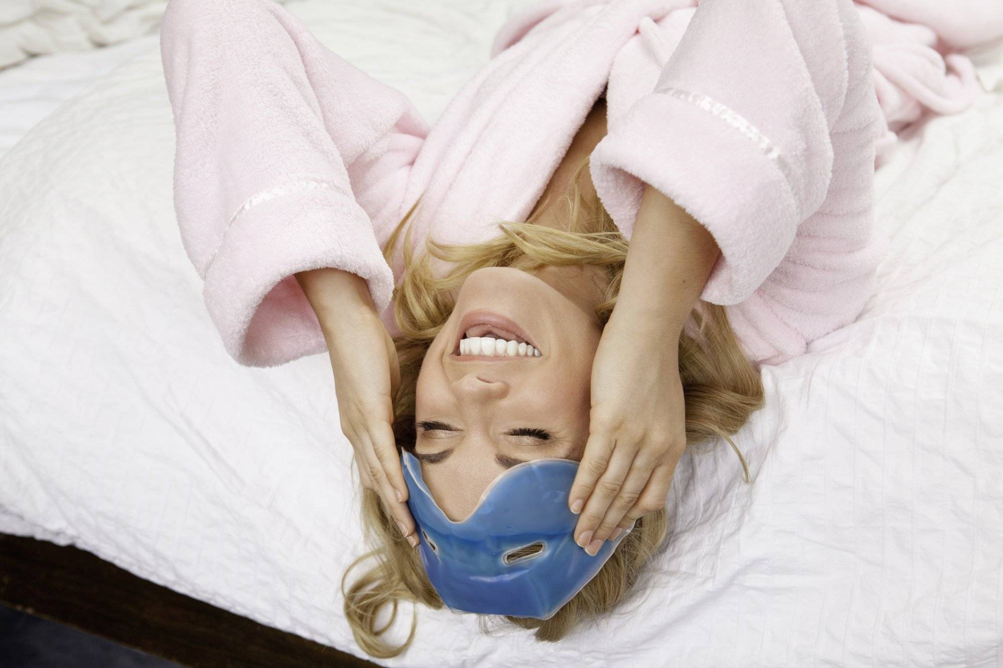 Woman on bed with eye mask on forehead Woman on bed with eye mask on forehead