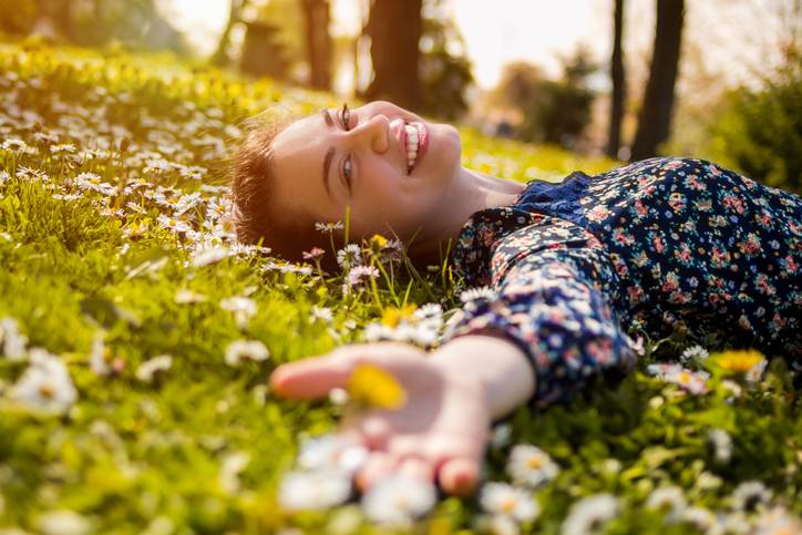 Pretty young teenage girl relaxing on a grass